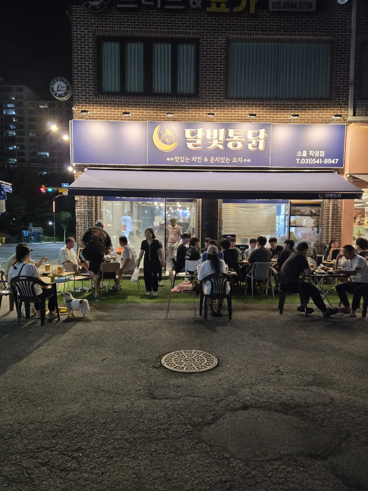손님으로 가득 찬 달빛통닭 소흘 직영점의 저녁 야외 테이블